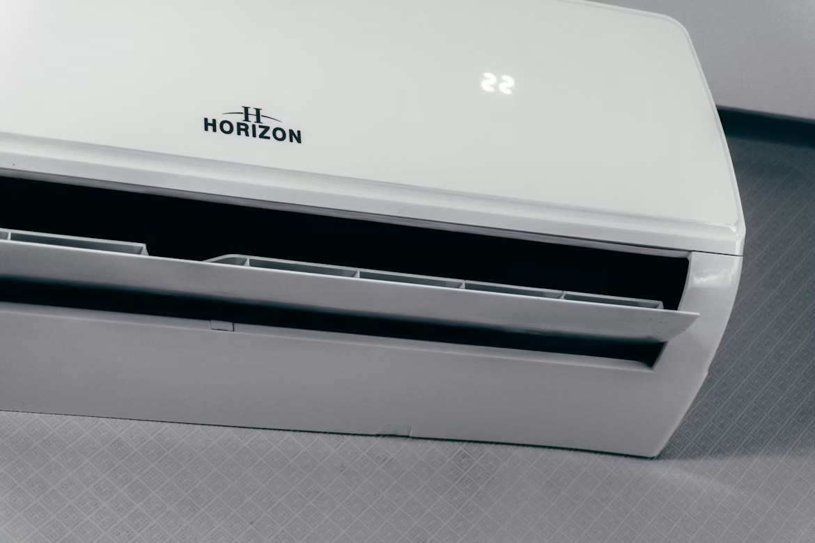 photo-1762341123870-d706f257a12e White wall-mounted Horizon air conditioner with vent open and digital display showing '22'